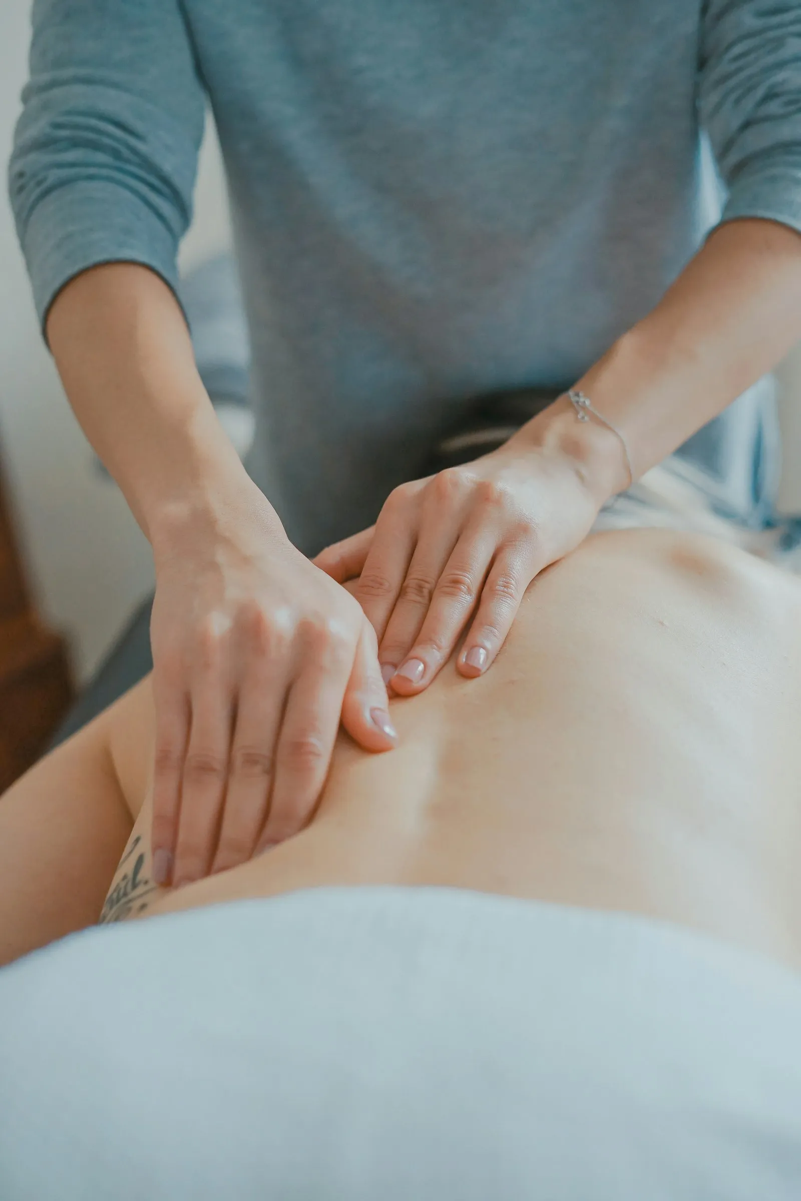 Close-up of a massage therapist's hands working on a client's back